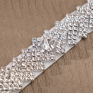 Detailed macro view of bridal leg garter featuring hand-stitched crystals and pearls