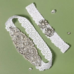 Detail of bridal lace garters featuring handcrafted white pearls and sparkling rhinestones