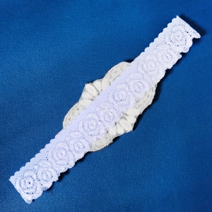 Detailed view of hand-sewn white bridal lace garter with pearl beads and sequins