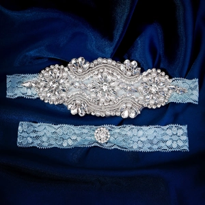 Elegant bridal garter set featuring blue lace with hand-sewn rhinestones and pearls