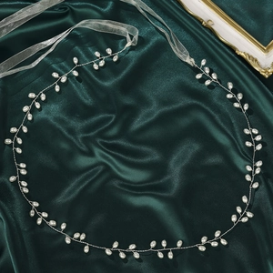 Elegant bridal vine belt with white pearls and silver wire on green silk background