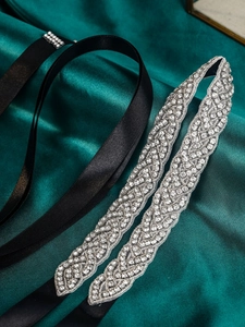 Detail of luxury bridal belt with hand-sewn silver rhinestones on black satin ribbon