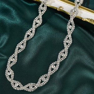 Close-up of hand-stitched silver bridal sash with shimmering rhinestones on silk