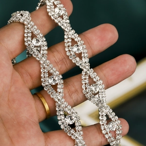Macro shot of silver bridal sash with hand-sewn rhinestones in a wavy pattern