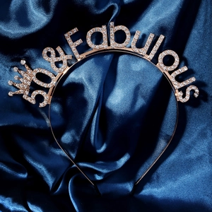 Macro detail of gold 30 & Fabulous headband with sparkling rhinestones on blue silk