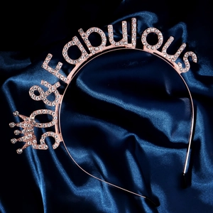 Macro detail of 50 & fabulous rose gold tiara with rhinestones on blue silk background
