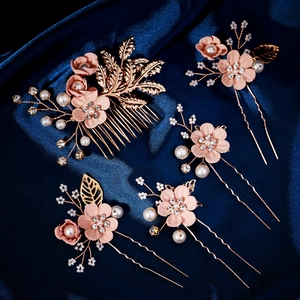 Detail of five-piece bridal hair set with pink fabric flowers and golden metal leaves