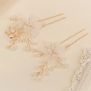 Detailed view of handmade tulle flower hair pins with white pearls and golden leaves
