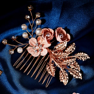 Close-up of pink fabric flowers and pearls on a rose gold bridal hair comb detail