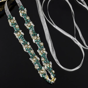 Detail of hand-sewn green and clear crystal leaf pattern on bridal organza sash
