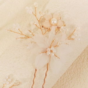 Detail of bridal hair pin with tulle flowers, pearls, and crystals on gold wire