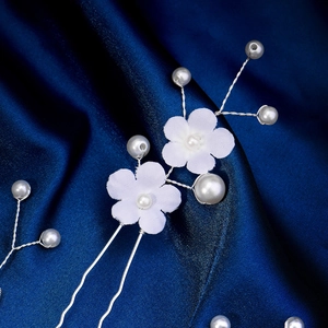 Lot d'épingles à cheveux de mariée avec fleurs blanches et perles sur fond de soie bleue