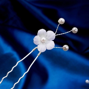 Détail d'épingle à cheveux mariée fleur blanche avec perles et pince en U ondulée argent