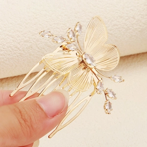 Détail d'un peigne à cheveux papillon doré orné de cristaux de zircon scintillants