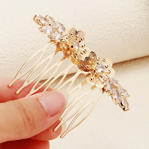 Détail du peigne à cheveux doré avec fleurs et strass brillants de forme marquise