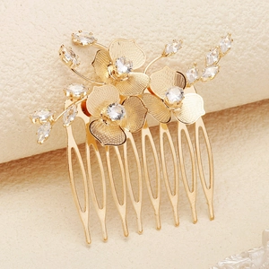 Détail du peigne à cheveux doré avec fleurs en métal et incrustations de zircons brillants