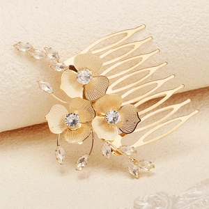 Vue détaillée d'un peigne à cheveux doré de luxe avec fleurs en zircon et feuillage