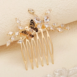 Détail d'un peigne à fleurs doré avec papillon en émail noir et cristaux zircons