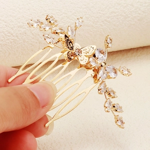 Détail d'un peigne à cheveux papillon doré orné de cristaux de zircon brillants