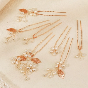 Golden bridal hair pin set with white pearls and metal leaves for wedding hairstyles