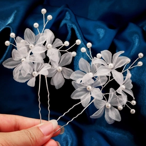 Détail d'épingles à cheveux fleurs en tulle blanc avec perles et fil d'argent torsadé