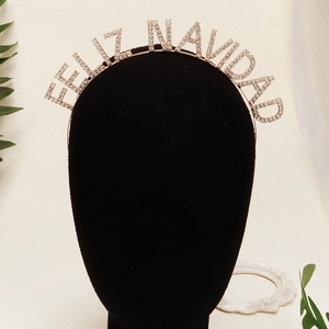 Detailed close-up of Feliz Navidad headband featuring sparkling rhinestones on gold metal