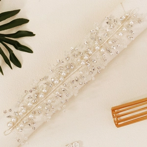 Détail de vigne à cheveux mariée argentée avec strass brillants et perles blanches
