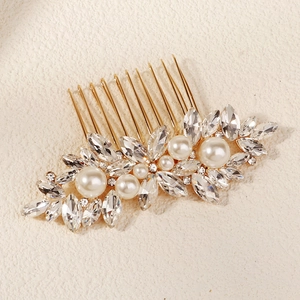 Macro view of bridal hair comb with pearls and marquise crystals on gold base