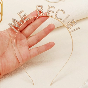 Detailed view of a gold party headband with sparkling rhinestone letters for New Year