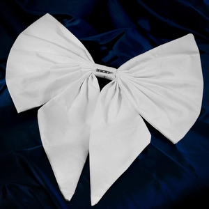 Close-up of oversized white handmade fabric bow brooch with metal safety pin back