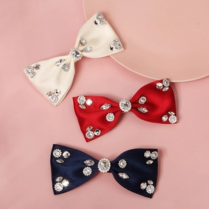 Close-up of elegant bow hair clips with sparkling rhinestones and shiny satin texture