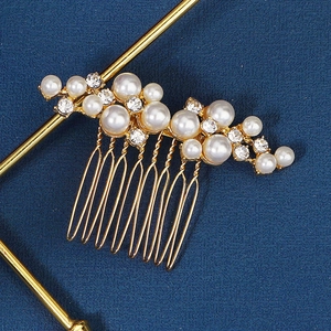 Detailed close-up of bridal hair comb with golden alloy base, pearls, and sparkling crystals