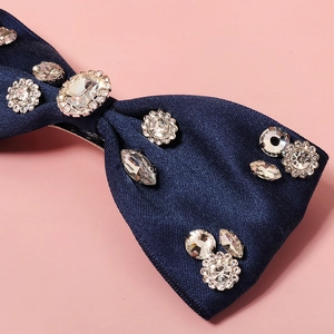 Detailed close-up of navy blue ribbon hair clip with sparkling crystal rhinestone embellishments