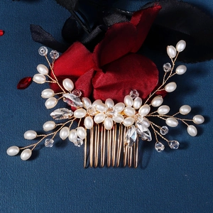 Detail of handmade gold bridal hair comb with elegant pearls and crystal vine design