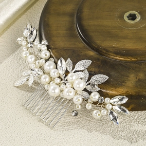 Detailed macro view of 10-tooth silver bridal hair comb with pearls and marquise crystals