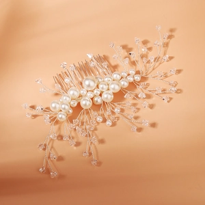 Close-up of handmade bridal hair comb with elegant pearls and crystal beads on silver wire