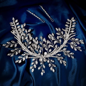 Detail of silver leaf bridal hair vine and crystal clips on luxury blue silk background