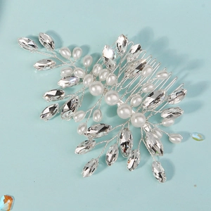 Close-up of bridal hair comb with pearls and marquise crystals on a blue background