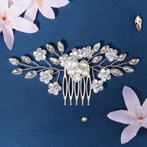 Detailed close-up of bridal hair comb with pearls, crystals and blue flowers