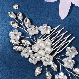 Detailed macro view of handmade bridal hair comb with silver wire, pearls, and rhinestones