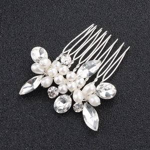 Macro shot of bridal hair comb with elegant white pearls and marquise cut crystals
