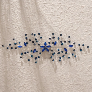 Détail d'un peigne à cheveux de mariée avec cristaux bleus et fleurs en fil d'argent