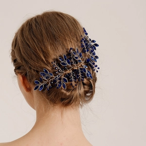 Détail d'un peigne à cheveux en cristal bleu saphir fait main dans un chignon de mariée