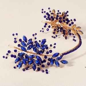 Détail des cristaux bleus et strass sur un peigne à cheveux floral doré pour mariée