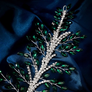 Detailed macro view of handmade bridal hairband with green rhinestones on blue silk