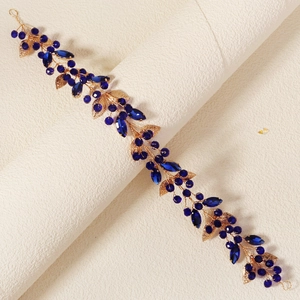 Détail d'un peigne à cheveux fait main avec cristaux bleu saphir et feuilles d'or