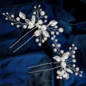 Vue détaillée d'épingles à cheveux de mariée avec feuilles argentées et perles sur soie