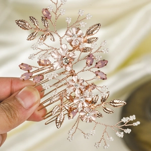 Détail de strass roses et perles blanches tissés à la main sur un peigne de mariée
