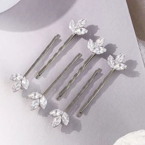 Détail de pinces à cheveux argentées avec trèfles en zircon marquise et barrettes plates en set