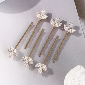Détail d'un lot de 7 pinces à cheveux dorées ornées de trèfles en zircon étincelant